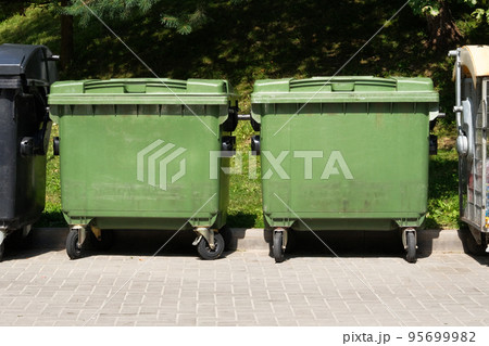 Dustbins being full with garbage. Garbage bins in city community. Green garbage bins in town. Dustbins being full with garbage. Garbage bins in city community. Green garbage bins in town. 95699982