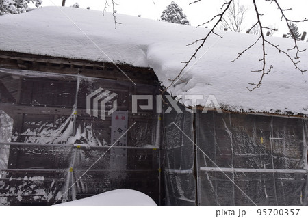 大量の雪が積もっている安久津八幡宮神社を脇から見ている風景 95700357