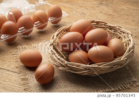 Heap of Chicken eggs on wicker basket on wooden plate background 95701345