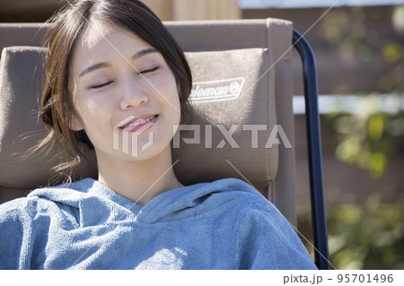 屋外サウナの前でサウナポンチョを着て外気浴をするサウナ女子 屋外サウナの前でサウナポンチョを着て外気浴をするサウナ女子 95701496