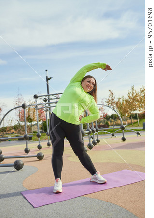 Outdoor training. Weight lost concept. Young woman doing fitness exercises at street public sports ground. Sunny autumn day. Sport, health, plans, body positive Outdoor training. Weight lost concept. Young woman doing fitness exercises at street public sports ground. Sunny autumn day. Sport, health, plans, body positive 95701698