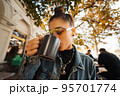 Cute young woman while drinking tea in modern street cafe 95701774