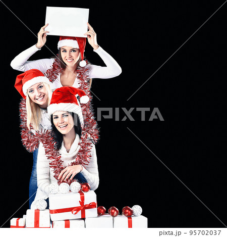 three young girls in costume of Santa Claus showing blank sheets three young girls in costume of Santa Claus showing blank sheets 95702037