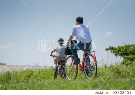初夏の澄んだ青空の下を自転車で走る親子（手賀沼サイクリングロード） 95702458