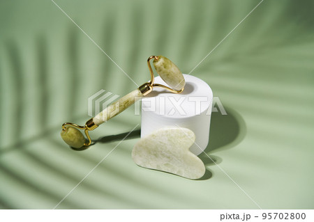 Green jade face roller and Gua Sha scraping for beauty facial massage therapy 95702800