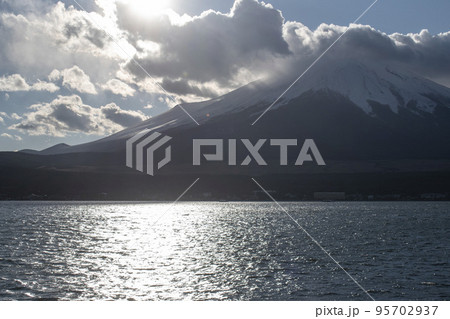 雲の切間から太陽の光のさす富士山 95702937