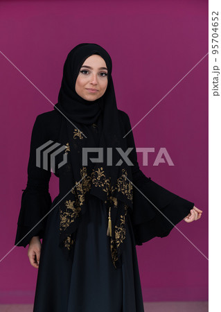 beautiful muslim woman in fashinable dress with hijab isolated on modern pink background representing concept of modern islam and ramadan kareem 95704652