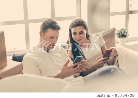 happy young couple looking at their smartphone screen . happy young couple looking at their smartphone screen . 95704709