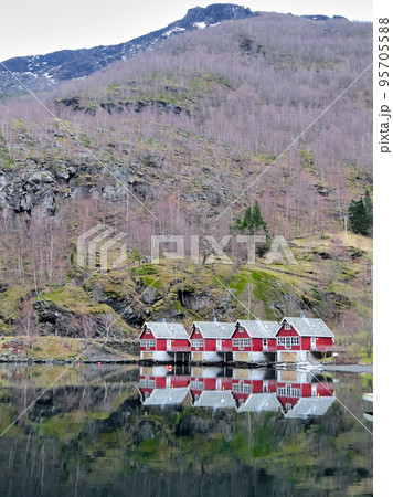 Reflection of a small houses in a fiord in winter 95705588