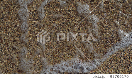 Texture of coarse sea sand close-up, small pebbles, sea water with foam For design, background, postcards, collages and compositions 95706170
