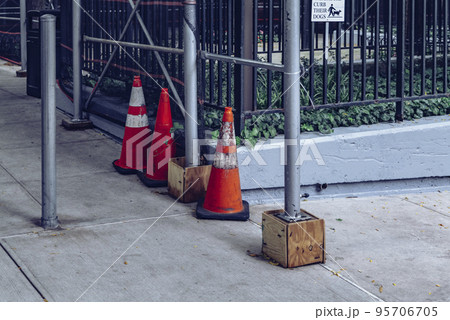 Orange Road Traffic Cone with White Stripes on Street 95706705