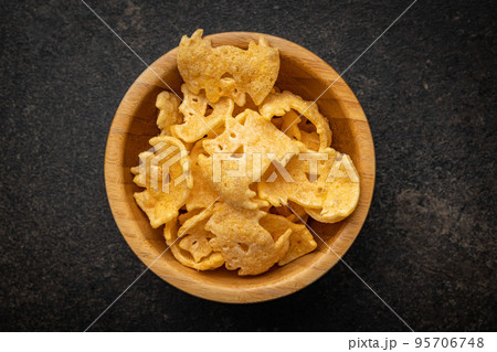 Halloween crispy bat shaped chips in bowl. Halloween crispy bat shaped chips in bowl. 95706748