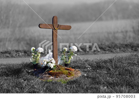 Dead on the road cross and flowers 95708003