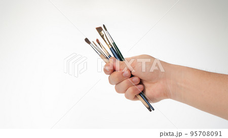men's hand with a set of tassels for the artist on a white background men's hand with a set of tassels for the artist on a white background 95708091
