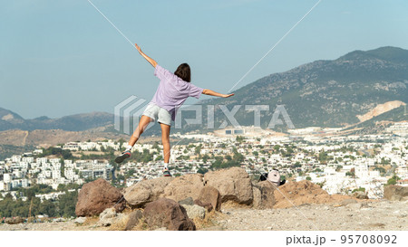 A woman on the observation deck with her arms open looks at the city and the sea from a height - travel, freedom, life A woman on the observation deck with her arms open looks at the city and the sea from a height - travel, freedom, life 95708092