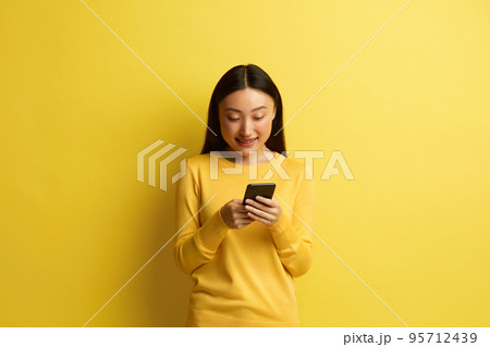 Happy Woman Holding Smartphone Isolated. Asian Girl Messaging Cellphone 95712439