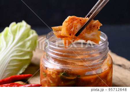 Kimchi cabbage in bowl eating by chopsticks, Asian fermented food Kimchi cabbage in bowl eating by chopsticks, Asian fermented food 95712648