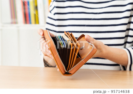 財布を開くカジュアル姿のミドル女性 95714638