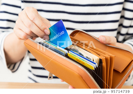 メンバーズカードを持つカジュアル姿のミドル女性 95714739