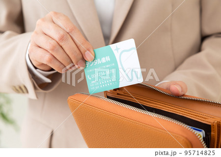 歯医者の診察券を持つスーツ姿のミドル女性 歯医者の診察券を持つスーツ姿のミドル女性 95714825