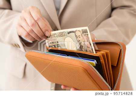 財布からお金を出すスーツ姿のミドル女性 95714828
