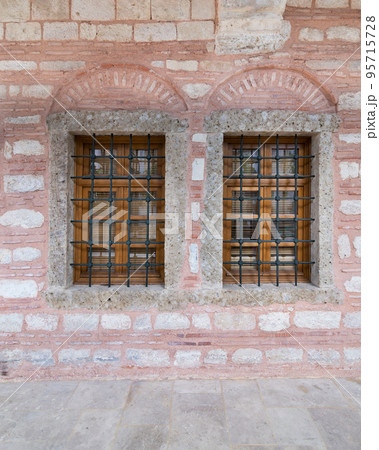 Two adjacent wooden arched windows in a red and white stone bricks wall, near Eyup Sultan Mosqoe, Istanbul, Turkey Two adjacent wooden arched windows in a red and white stone bricks wall, near Eyup Sultan Mosqoe, Istanbul, Turkey 95715728