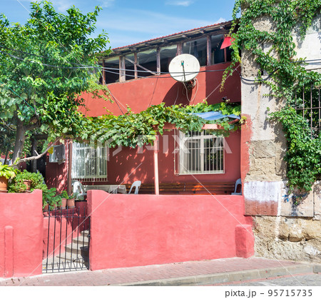 Old red traditional residential hosue, with wrought iron windows, climber plants, and trees, Balat, Istanbul, Turkey Old red traditional residential hosue, with wrought iron windows, climber plants, and trees, Balat, Istanbul, Turkey 95715735