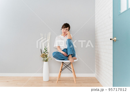部屋で椅子に座りながら悩むストレスを抱えたアジア人女性 部屋で椅子に座りながら悩むストレスを抱えたアジア人女性 95717012
