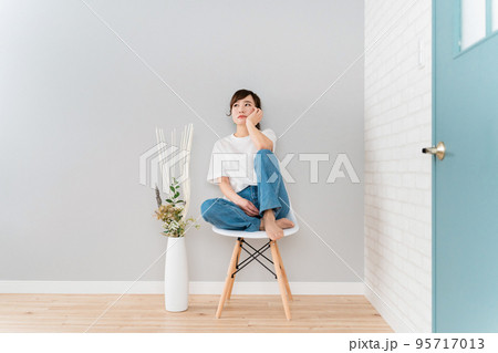 部屋で椅子に座りながら悩むストレスを抱えたアジア人女性 部屋で椅子に座りながら悩むストレスを抱えたアジア人女性 95717013