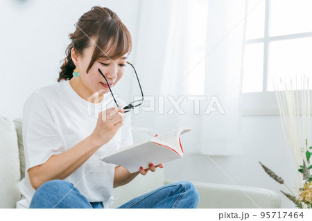 メガネをかけて本を読むアジア人女性（読書） 95717464