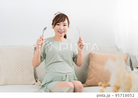 スプーンとフォークを持つ日本人の妊婦(大食い・食事) スプーンとフォークを持つ日本人の妊婦(大食い・食事) 95718052