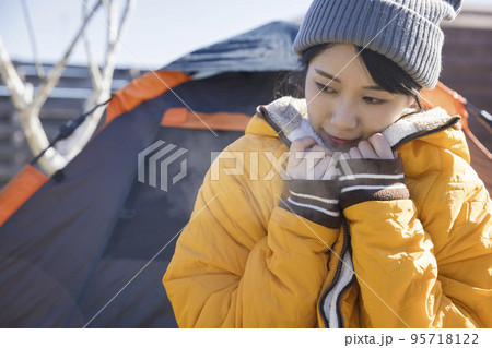 冬キャンイメージ　キャンプで防寒する若い女性 95718122