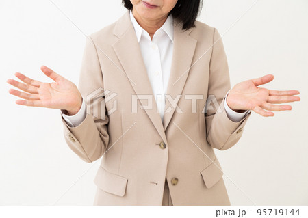 両手を広げてお手上げポーズをするスーツを着たミドル女性 両手を広げてお手上げポーズをするスーツを着たミドル女性 95719144