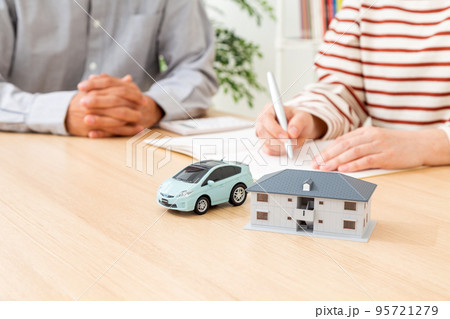 家計を計算するミドル夫婦と車と家の模型 95721279