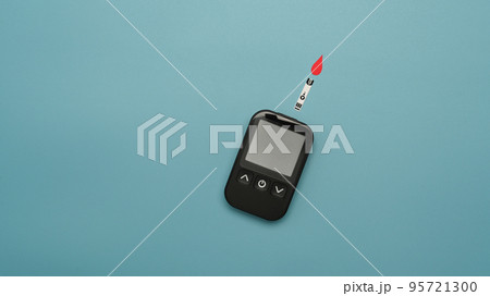 Top view of a glucose meter on blue background. Medicine, diabetes and health care concept Top view of a glucose meter on blue background. Medicine, diabetes and health care concept 95721300