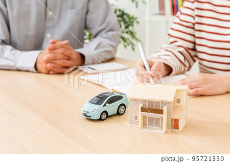 家計を計算するミドル夫婦と車と家の模型 95721330