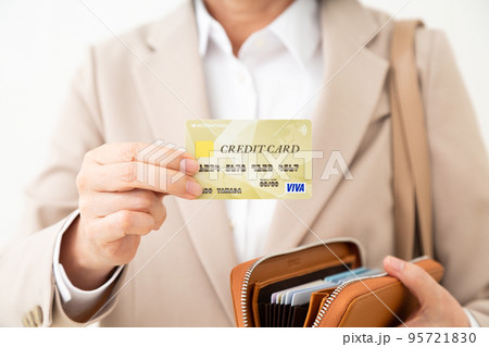 クレジットカードを持つスーツ姿のミドル女性 95721830