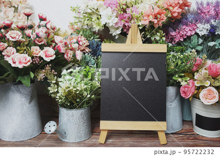 Empty easel chalkboard sign mockup with flowers decoration Empty easel chalkboard sign mockup with flowers decoration 95722232