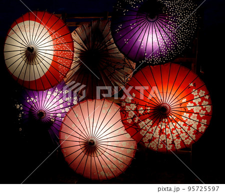 暗闇に浮かび上がるカラフルな和傘のイルミネーション 95725597