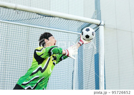 サッカーボールをキャッチするゴールキーパーの男性 サッカーボールをキャッチするゴールキーパーの男性 95726652