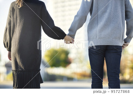 コートを着て手を繋いで散歩をするカップルの後ろ姿 95727868