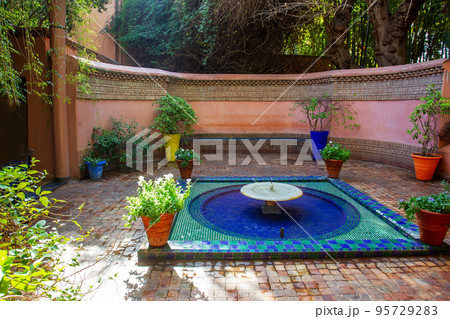 Entrance place with fountain and potted plants with colorful pots  in Majorelle garden 95729283