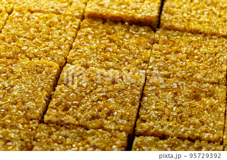 Brown sugar cubes background. Demerara golden brown sugar macro diagonal shot Brown sugar cubes background. Demerara golden brown sugar macro diagonal shot 95729392