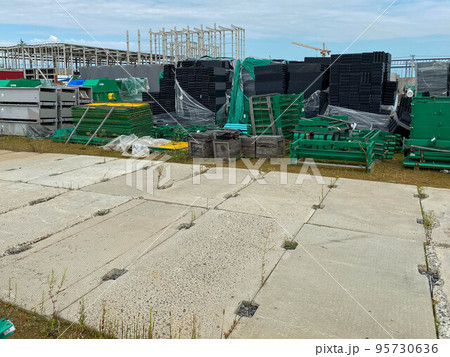 A large outdoor warehouse at a construction site, a warehouse for industrial equipment and materials in boxes at an open-air storage site A large outdoor warehouse at a construction site, a warehouse for industrial equipment and materials in boxes at an open-air storage site 95730636