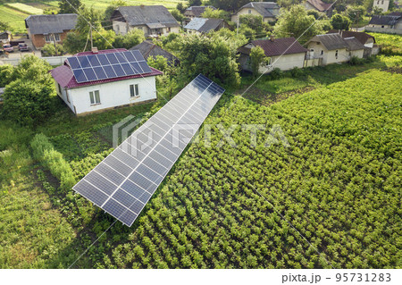 Aerial view of a house with blue solar panels for clean energy. Aerial view of a house with blue solar panels for clean energy. 95731283