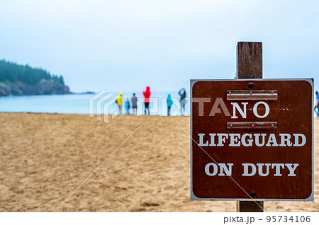 Posted sign at a sand beach stating No Lifeguard on Duty Posted sign at a sand beach stating No Lifeguard on Duty 95734106