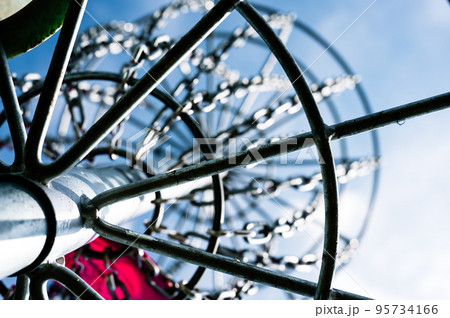 Underneath a disc golf goal looking up with selective focus on the chain basket. 95734166