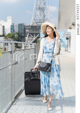 スーツケースを引いて名古屋観光をする若い女性 95734357