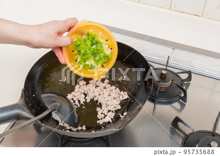 【マーボー茄子を作る　炒め上がったひき肉に青葱を入れる】 95735688