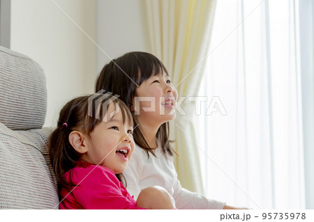リビングで笑う姉妹 95735978